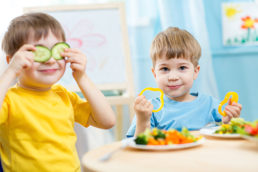 Two boys eating vegetables