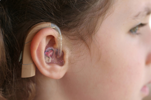 Photo of girl with a hearing aid in her ear