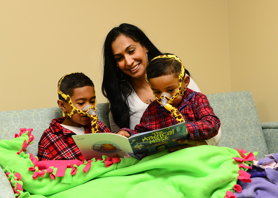 Mom reading a story to her childrens wearing a mask