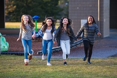 Girls holding hands and running together outside