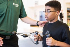 Children's Physical Therapist working with a boy with motion and function testing