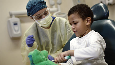 Dr. Greene uses Aydan's dinosaur to teach him how to brush his teeth