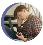 A photo of a child looking frustrated holding a computer