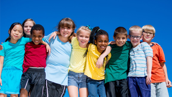 Photo of several children with arms around each other